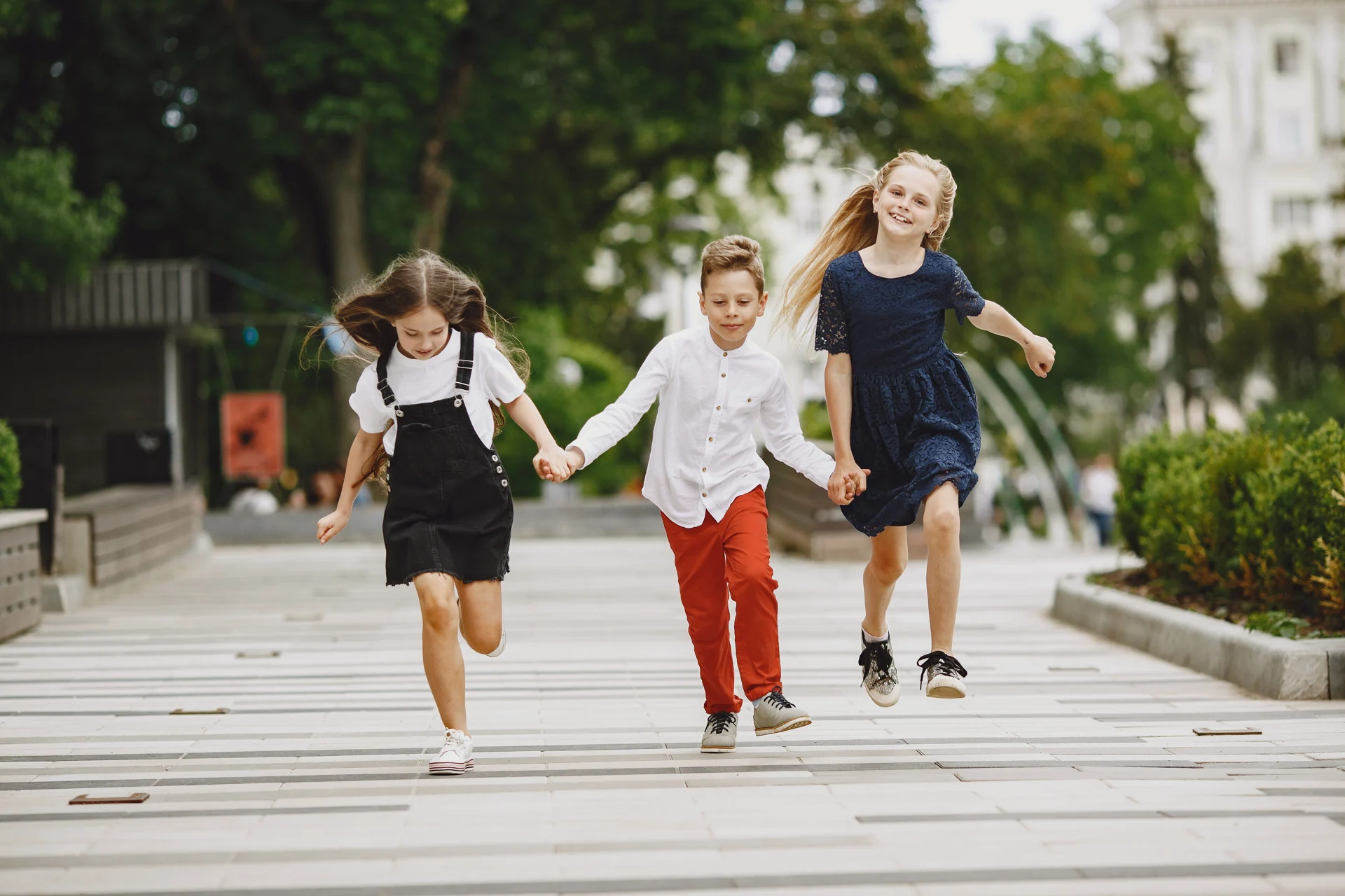 Children running hand in hand outdoors